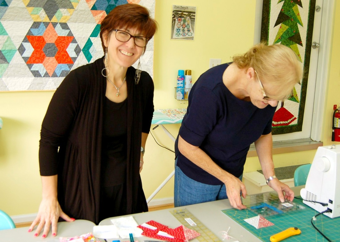 Linda assists a fellow quilter.